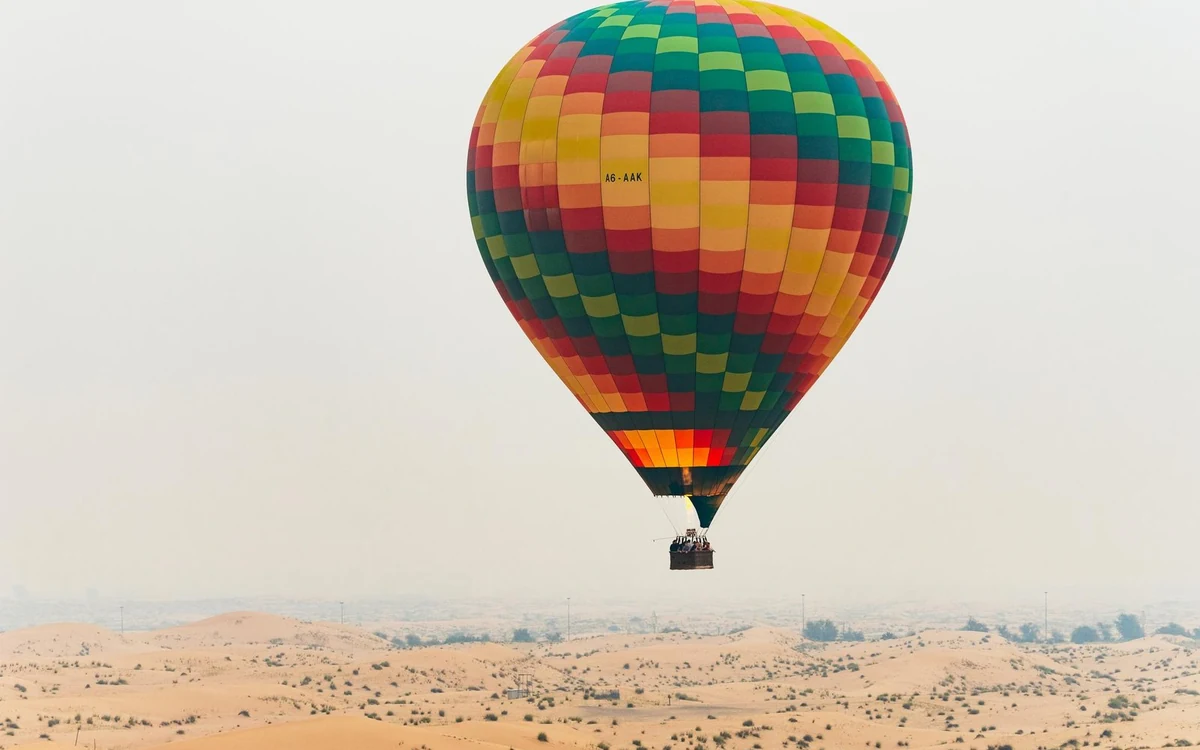 Una mongolfiera che si alza sulle dune alle prime luci fuori Dubai